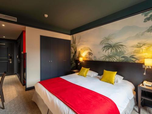 a bedroom with a large bed with a red blanket at Mercure Bordeaux Chateau Chartrons in Bordeaux