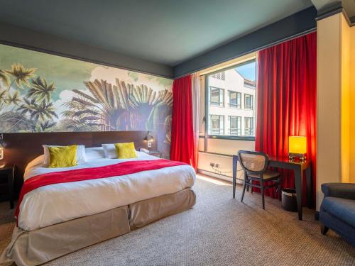 a bedroom with a large bed and a large window at Mercure Bordeaux Chateau Chartrons in Bordeaux