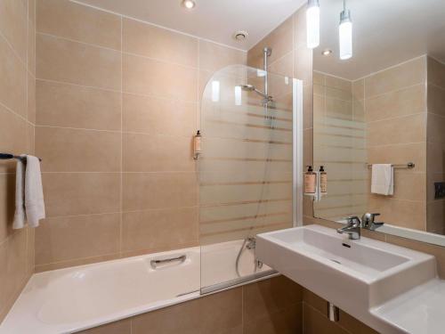 a bathroom with a tub and a sink and a shower at Mercure Bordeaux Chateau Chartrons in Bordeaux