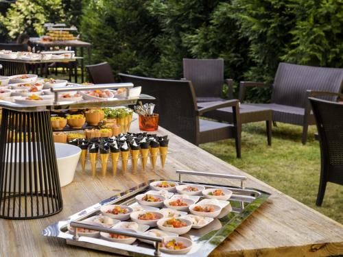a table with plates of food and drinks on it at Mercure Bordeaux Chateau Chartrons in Bordeaux