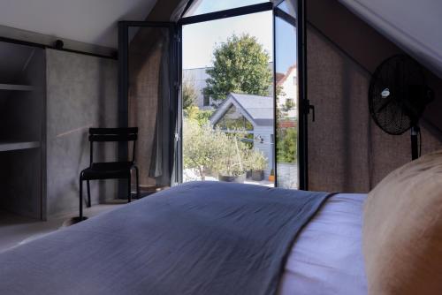 Maison contemporaine Centre DEAUVILLE - " 3 NUITS MINIMUM" في دوفيل: غرفة نوم بها سرير ونافذة كبيرة