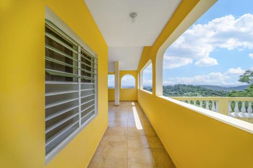 a balcony with a yellow wall and a window at Hilltop Getaway with Huge Terrace in Fajardo