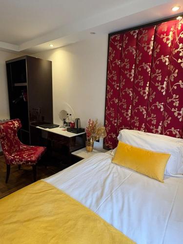 a bedroom with a bed with a red wall at Muthu Oban Regent Hotel in Oban