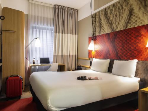 a hotel room with a large white bed and a desk at ibis Paris Place d’Italie 13ème in Paris