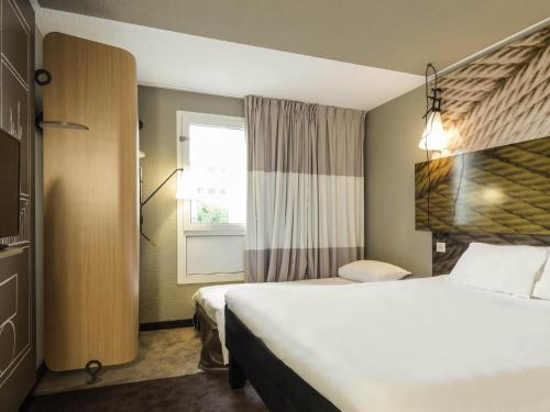 a hotel room with two beds and a window at ibis Paris Place d’Italie 13ème in Paris