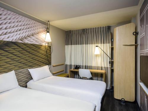 a hotel room with two beds and a desk at ibis Paris Place d’Italie 13ème in Paris