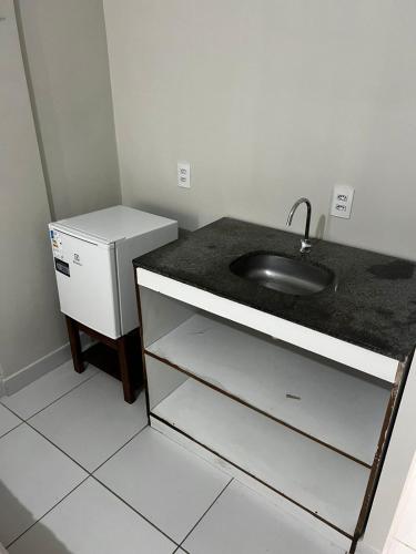 a bathroom with a sink and a refrigerator at Residencial Sol - Cidade alta in Natal