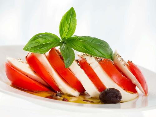 a piece of fruit with a green leaf on a plate at ibis Sète Balaruc les Bains Bien-être et Spa in Balaruc-les-Bains