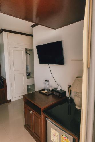 a room with a flat screen tv on the wall at Orchid Hotel and Spa Kalim Bay in Patong Beach