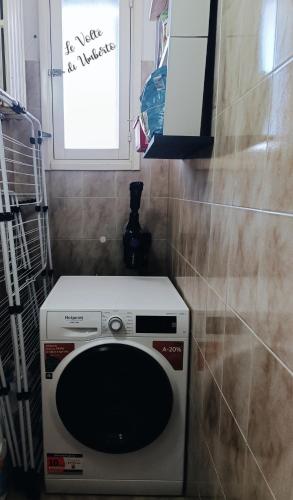 a washing machine in a bathroom with a window at Le volte di Umberto: camera e rilassante terrazzo in Sogliano Cavour