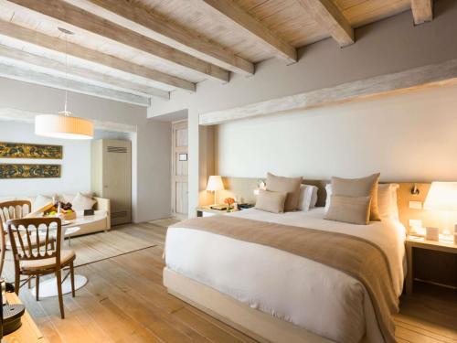 a bedroom with a large bed and a desk at Sofitel Legend Santa Clara Cartagena in Cartagena de Indias