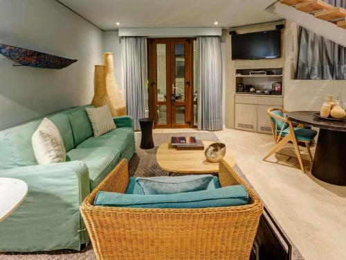 a living room with a green couch and a table at Sofitel Legend Santa Clara Cartagena in Cartagena de Indias