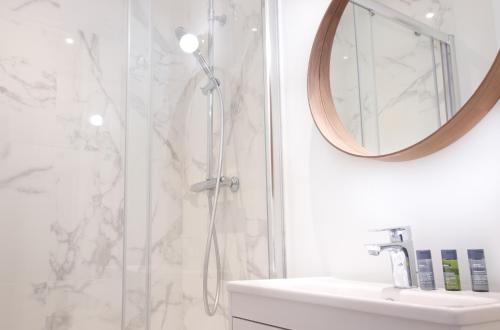 a bathroom with a shower and a sink and a mirror at Appartements - Bordeaux Centre Gare in Bordeaux
