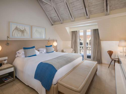 a bedroom with a large bed with blue pillows at Sofitel Legend Santa Clara Cartagena in Cartagena de Indias