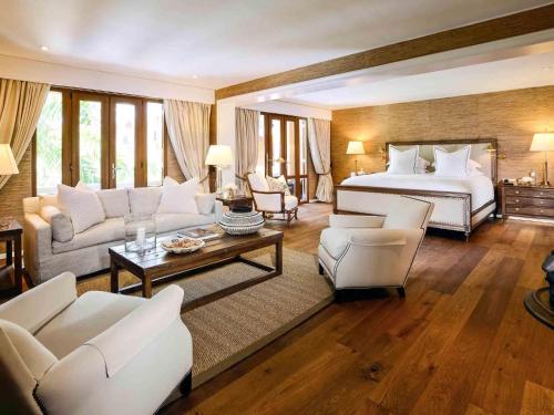 a large bedroom with a bed and a living room at Sofitel Legend Santa Clara Cartagena in Cartagena de Indias