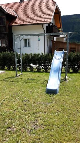 a blue slide in a yard with a house at Ferienhaus Silja in Steindorf am Ossiacher See