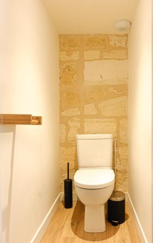 a bathroom with a white toilet in a room at Appartements - Bordeaux Centre Gare in Bordeaux