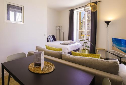 a living room with two couches and a table at Appartements - Bordeaux Centre Gare in Bordeaux