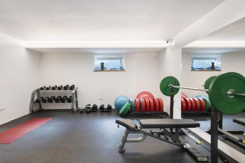 a gym with dumbbells and other equipment in a room at Hotel Residence Olympia Sarntal in Sarntal