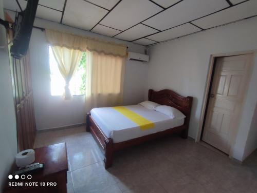 a bedroom with a bed and a window at HOSPEDAJE CASA JENIFER SPA MOMPOXx in Mompós