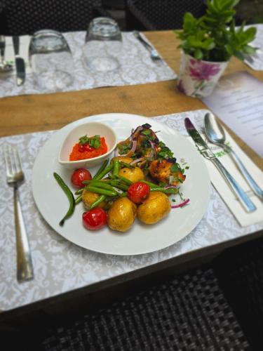 a plate of food with vegetables on a table at Areal Botanika in Unhošť