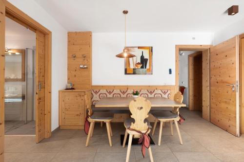 a dining room with a wooden table and chairs at Hotel Residence Olympia Sarntal in Sarntal