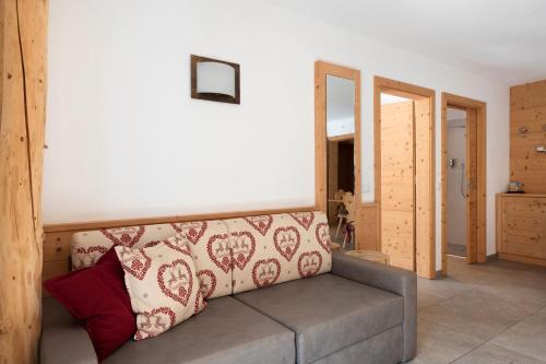 a living room with a couch and a mirror at Hotel Residence Olympia Sarntal in Sarntal
