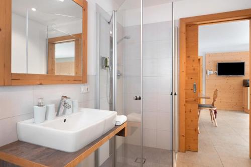 a bathroom with a sink and a shower at Hotel Residence Olympia Sarntal in Sarntal