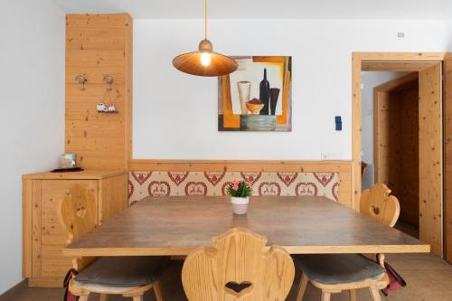 a dining room with a wooden table and chairs at Hotel Residence Olympia Sarntal in Sarntal