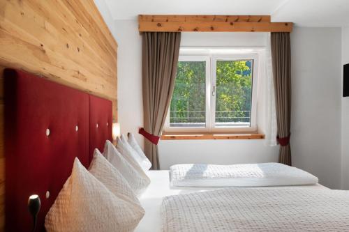 a bedroom with two beds and a window at Hotel Residence Olympia Sarntal in Sarntal