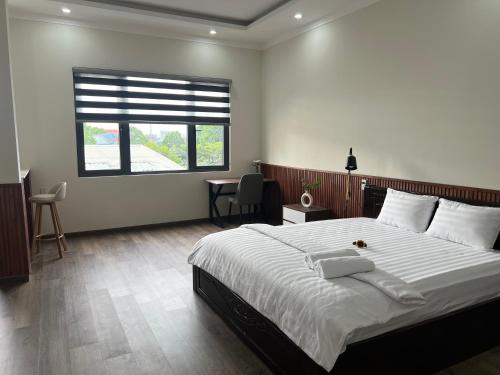 a bedroom with a large bed and a window at The Sun Hotel in Long Bình