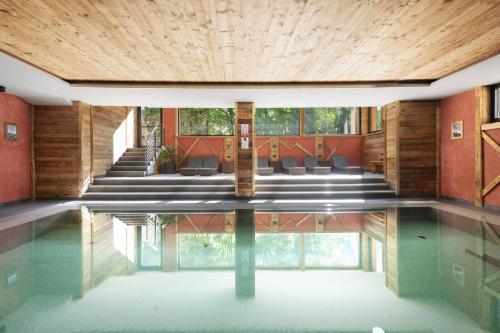 a pool in a house with a wooden ceiling at Hotel Residence Olympia Sarntal in Sarntal