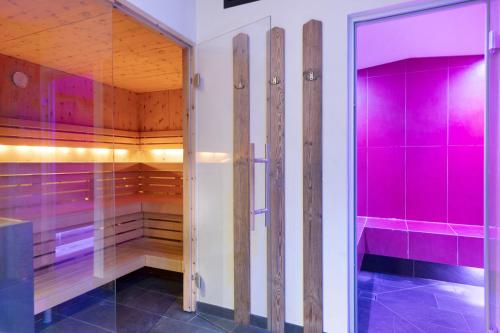 a walk in shower with pink and purple cabinets at Hotel Residence Olympia Sarntal in Sarntal