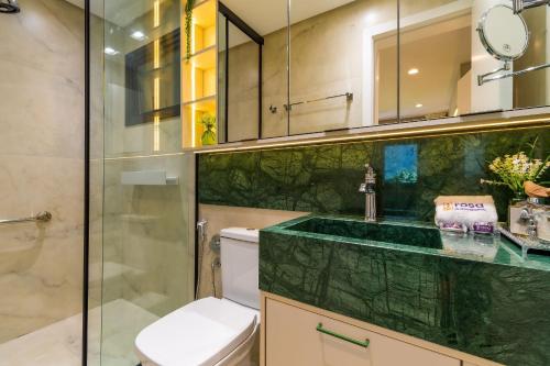 ein Badezimmer mit Toilette und Glasdusche in der Unterkunft Rosa Edificio Residencial Storia in Gramado