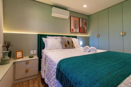 ein Schlafzimmer mit einem Bett mit Handtüchern darauf in der Unterkunft Rosa Edificio Residencial Storia in Gramado