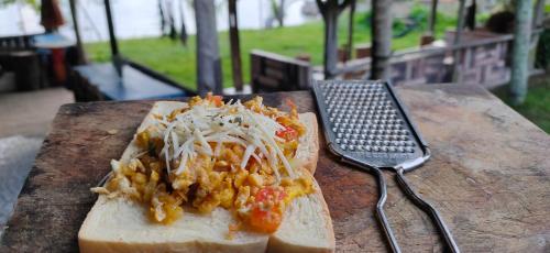 a piece of bread with salsa and cheese and a fork at Sarah's Cottage Toba Samosir in Ambarita