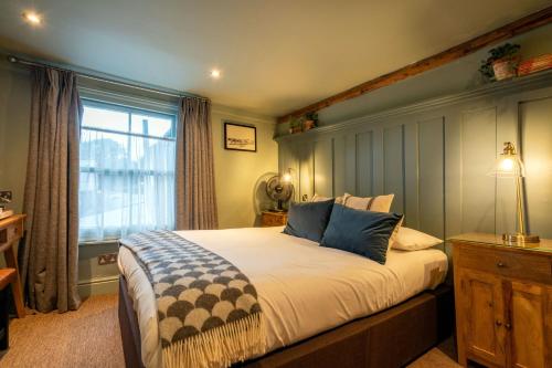 a bedroom with a large bed and a window at The Bull Inn in Mildenhall
