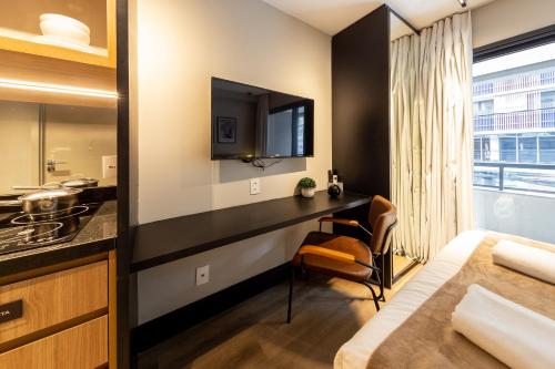 una camera da letto con un letto e una scrivania in una stanza di BHomy Step a San Paolo