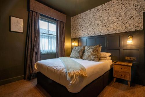 a bedroom with a large bed and a window at The Bull Inn in Mildenhall