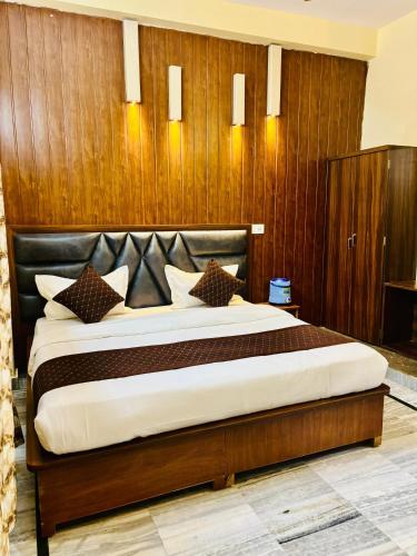 a bedroom with a large bed with a wooden wall at Hotel Heritage in Varanasi