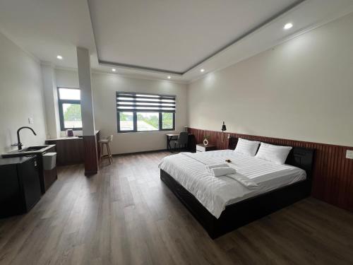 a bedroom with a large bed and a bathroom at The Sun Hotel in Long Bình