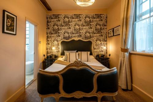 a bedroom with a large bed and a window at The Bull Inn in Mildenhall