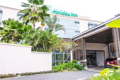 a building with a sign on the front of it at Holiday Inn Mauritius Mon Trésor by IHG in Blue Bay