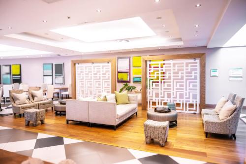 a lobby with couches and chairs and a table at Holiday Inn Mauritius Mon Trésor by IHG in Blue Bay