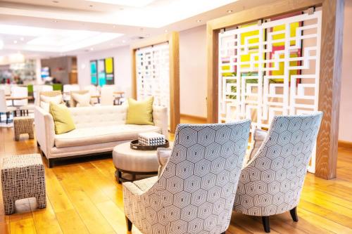 a living room with two chairs and a couch at Holiday Inn Mauritius Mon Trésor by IHG in Blue Bay