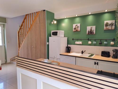 a kitchen with a counter and a green wall at Duplex for 4 people in Folligny