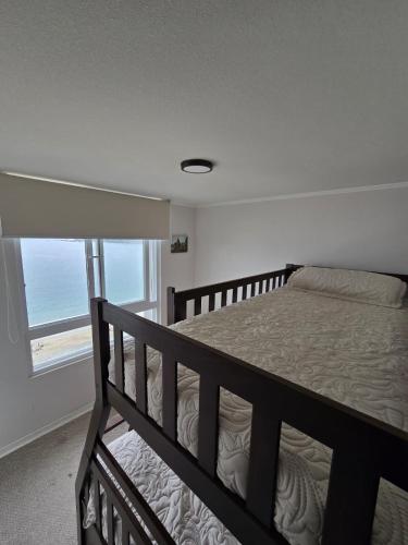a bedroom with a bed with a view of the ocean at Dpto Vista al Mar, La Herradura in Coquimbo