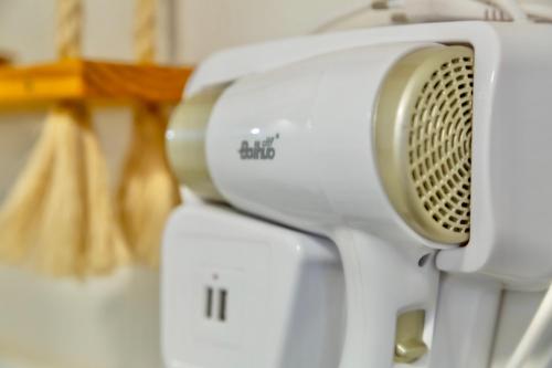 a close up of a white hair dryer at Contêiner 10 Hospedagem in Serra