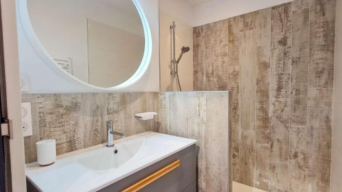 un baño con lavabo y espejo en Superbe villa avec piscine chauffée, boulodrome et parking, en Sainte-Marie-de-Ré