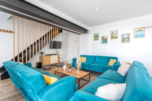 a living room with blue couches and a table at Gîte Milena - SPA - Puy duFou - Grande capacité in Les Épesses